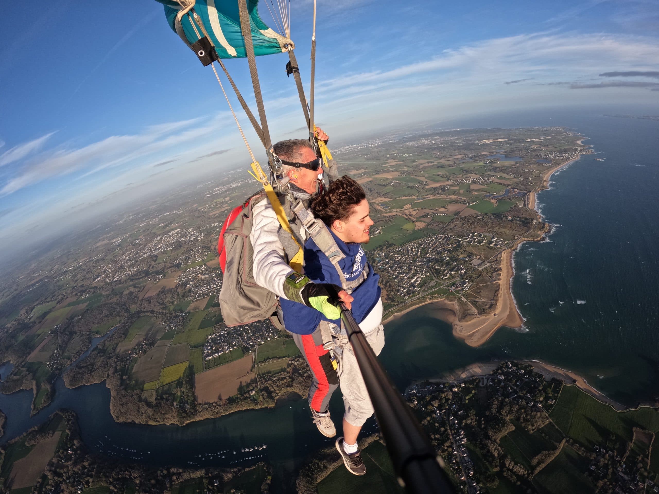 Baptême tandem sous parachute vert regardant l'horizon avec moniteur, vue aérienne sur un estuaire et la côte bretonne de Guidel – Saut en parachute Bretagne